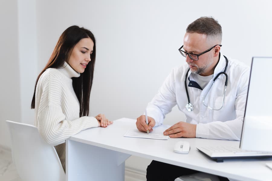 Médico prescreve receita para mulher paciente