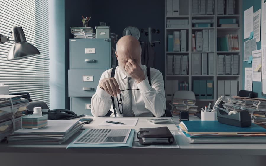 homem estressado em mesa de trabalho