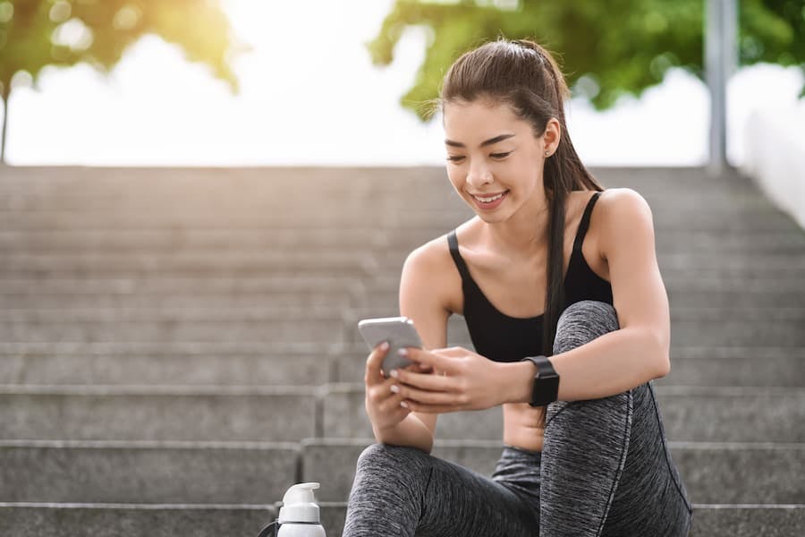Mulher fitness confere celular