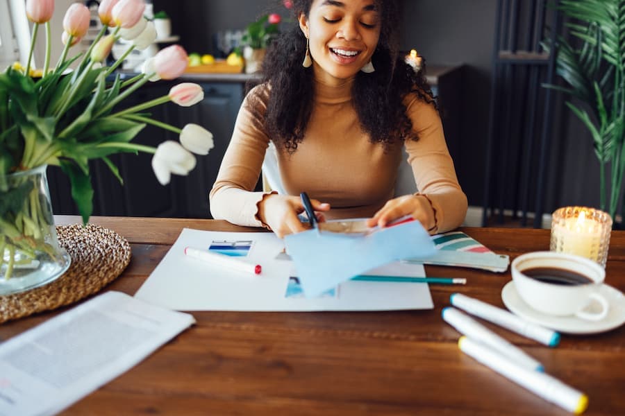 Mulher na mesa de escritório com flores papeis e café