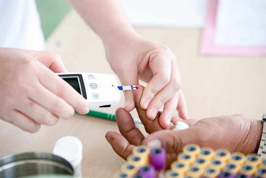 mãos de enfermeira fazem teste de diabetes em mãos de paciente