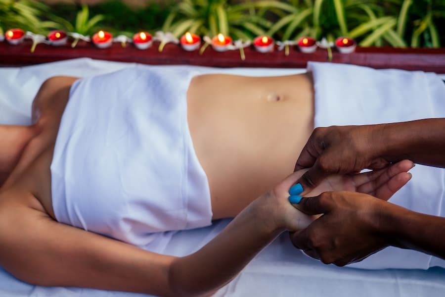 mulher recebe reflexologia nas mãos