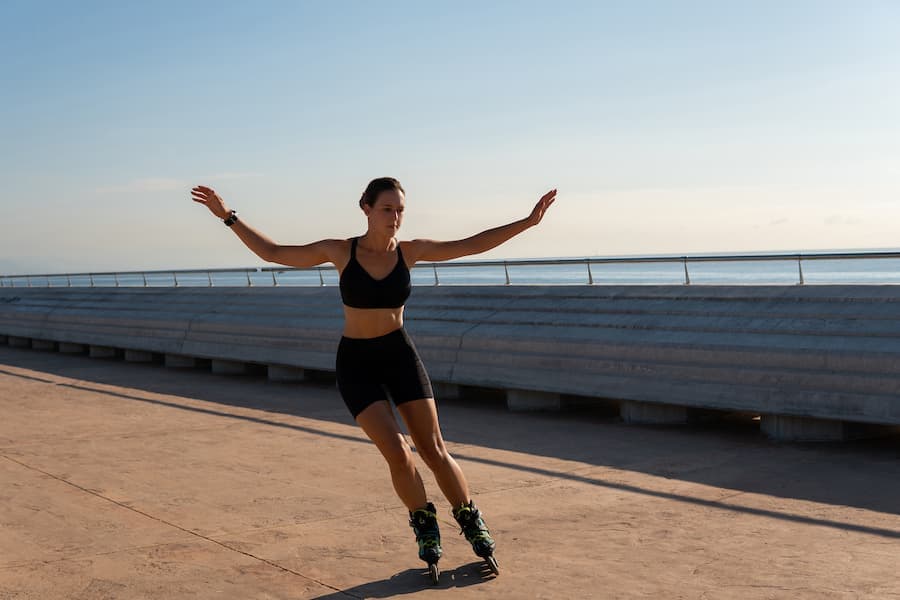 Mulher jovem pratica patinação em pista de atletismo