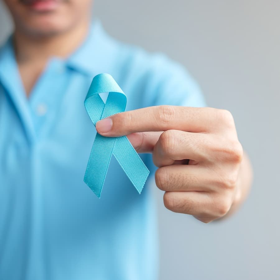 Homem segura fita azul da campanha Novembro Azul, contra o câncer de próstata