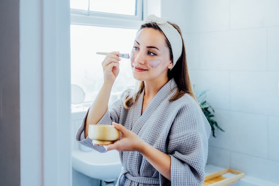 Jovem mulher usa creme facial