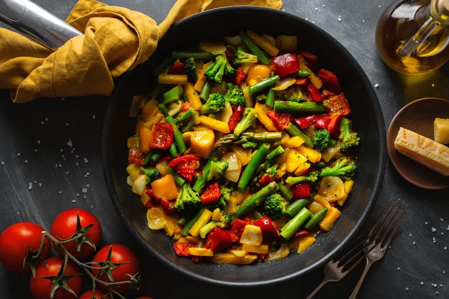frigideira com vários legumes picados
