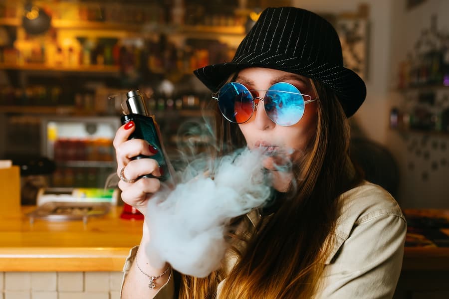 Garota fuma dispositivo vape