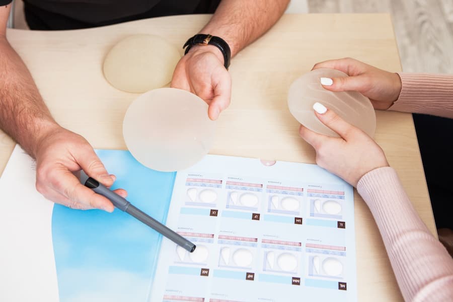 Mãos de médico mostra implantes de silicone