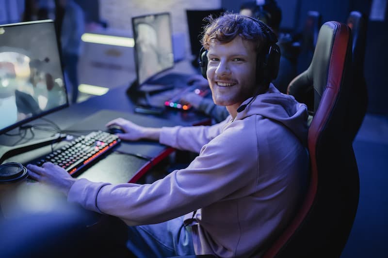 Jogador sorridente olhando para a câmera enquanto joga videogame