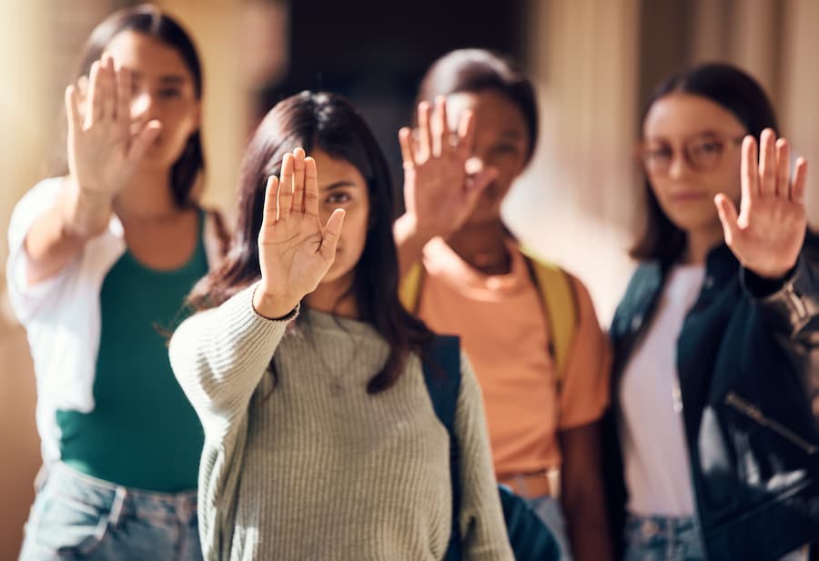 Jovens mulheres fazem sinal de parar com as mãos