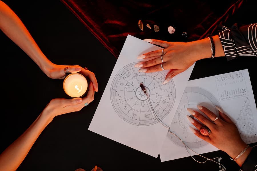 leitura de mapa astral e numerologia mãos sobre um mapa do zodíaco