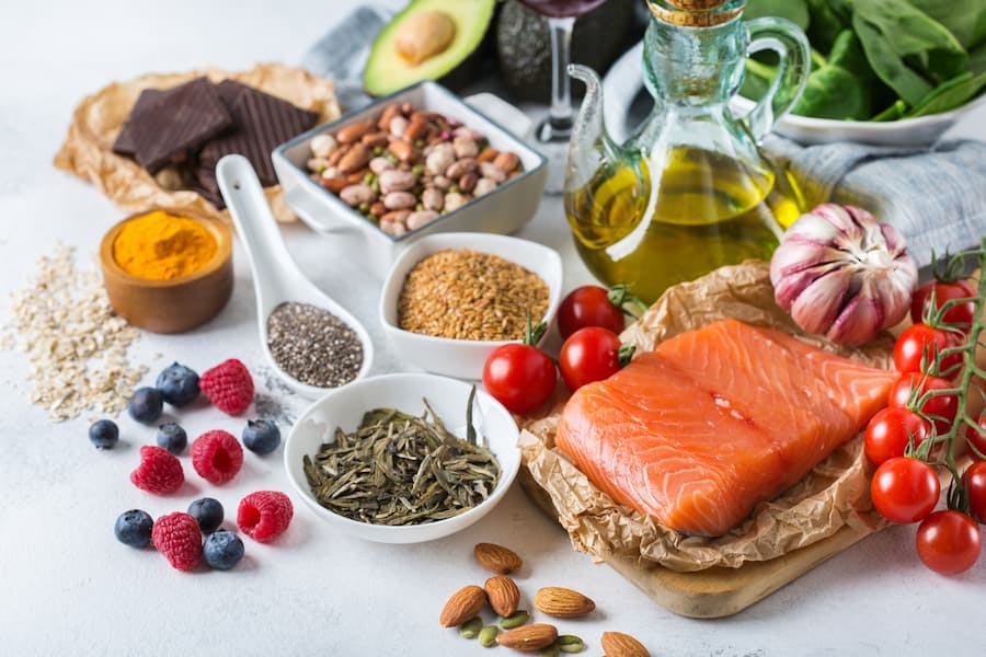 mesa com frutas, legumes, peixe, grãos alimentos conhecidos da dieta mediterrânea