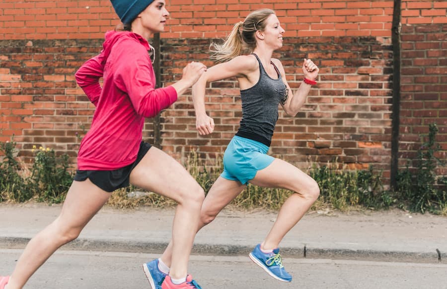 Duas jovens mulheres praticam corrida na rua