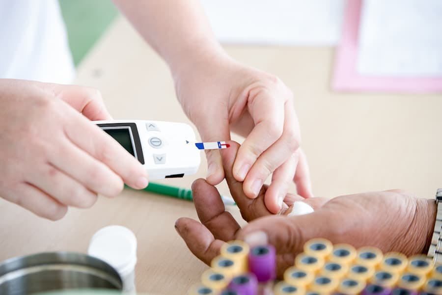 mãos de enfermeira fazem teste de diabetes em mãos de paciente