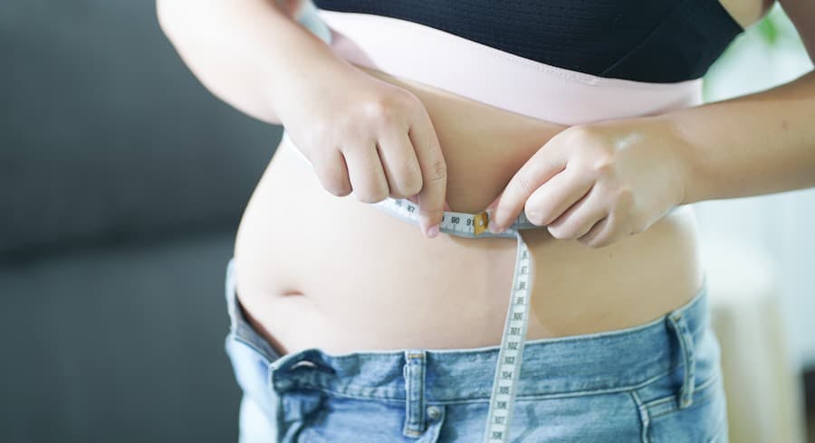 Cintura de mulher obesa com fita métrica