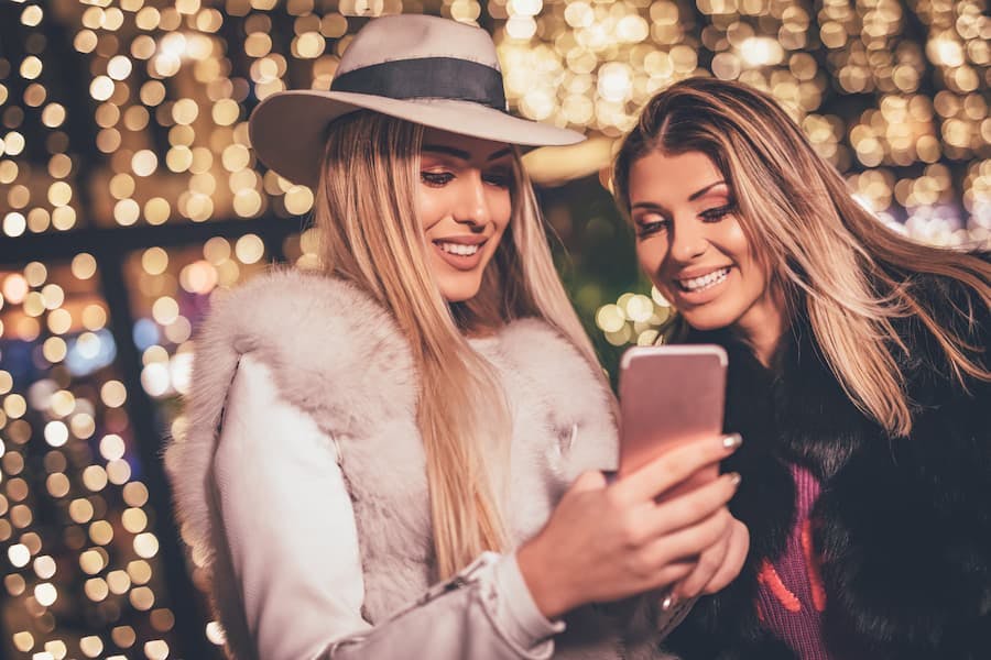 Duas mulheres jovens olham o celular