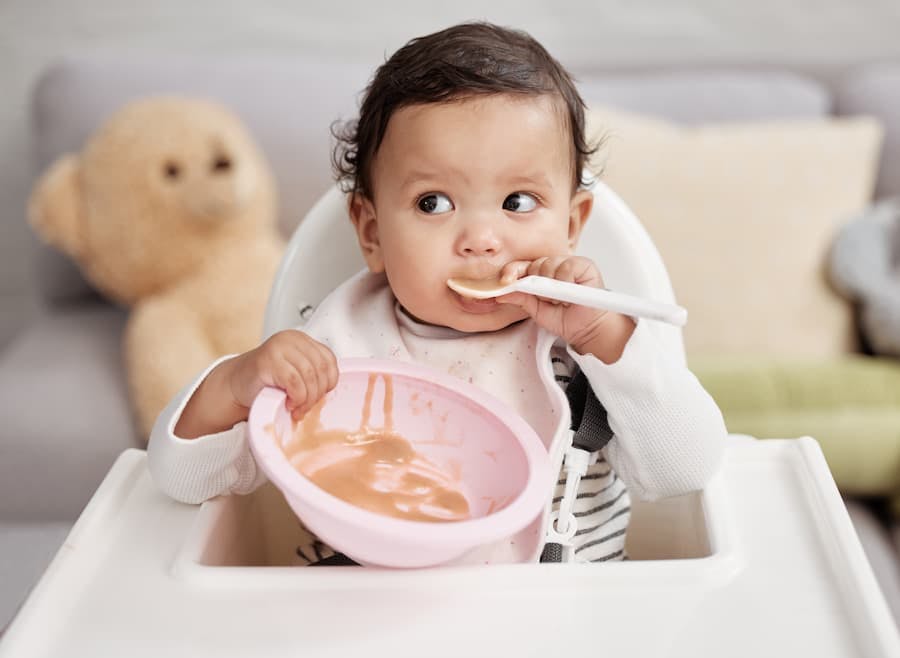 Bebê se alimenta, usando colher e pratinho na cadeirinha