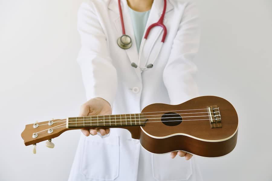 Médica segura ukelelê (pequeno violão)