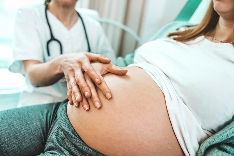 Médico examina mulher grávida