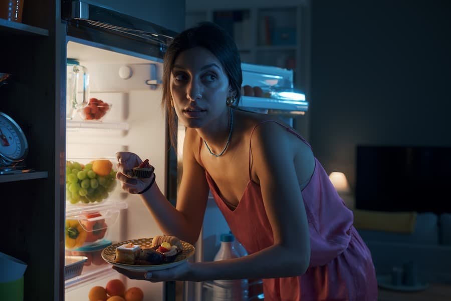 Mulher jovem assalta doces na geladeira no meio da noite