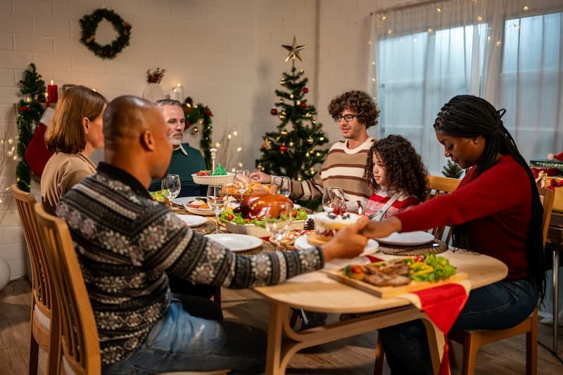 Família faz oração de natal na mesa da ceia